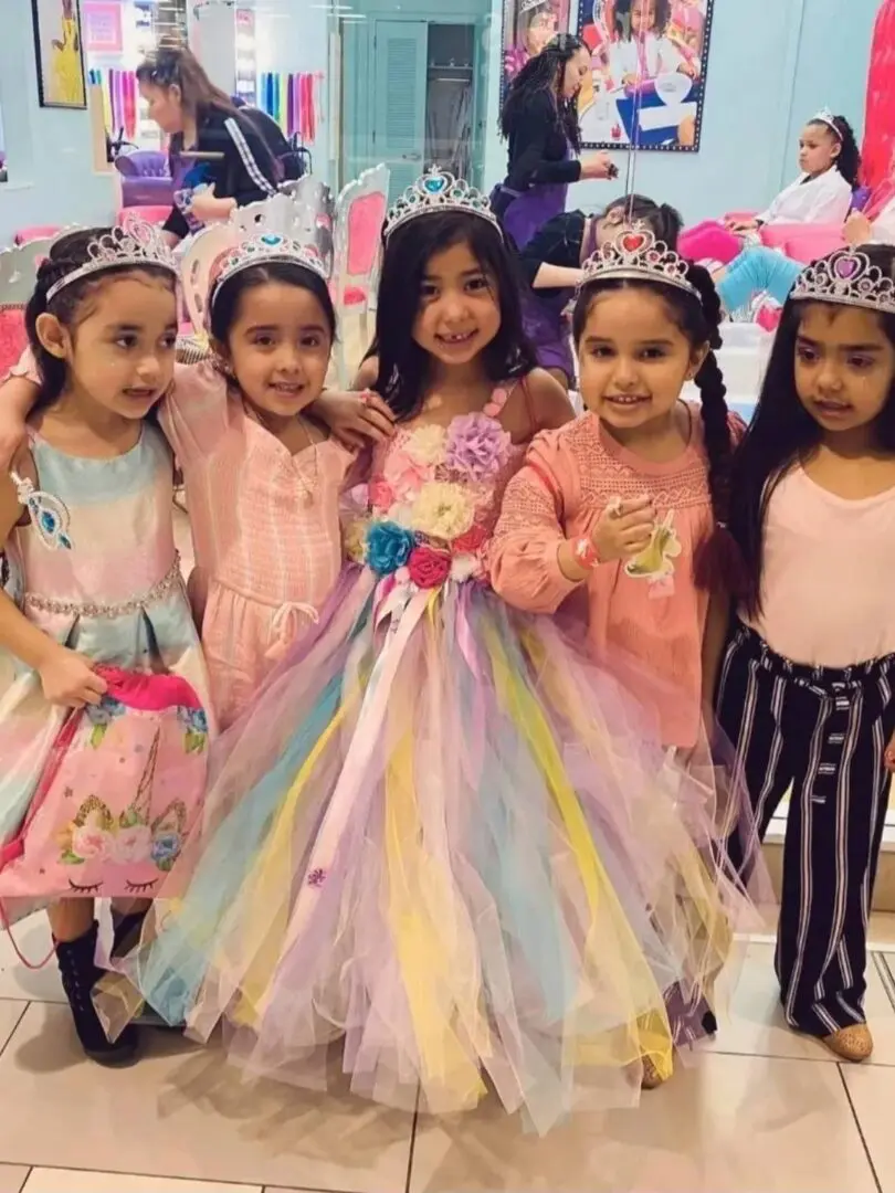 A group of girls in princess dresses posing for the camera.
