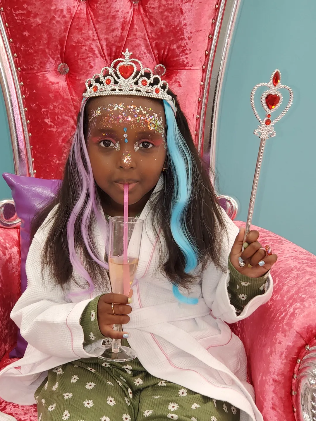 A little girl with long hair and makeup on her face.